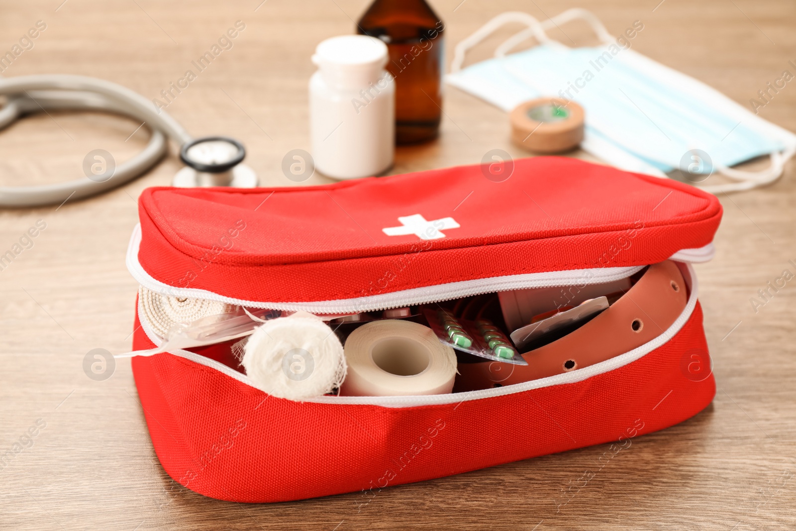Photo of First aid kit on wooden table, closeup. Health care