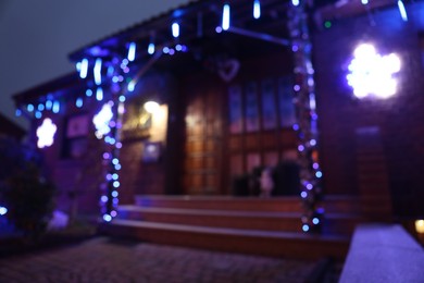 Photo of Blurred view of beautiful house decorated for Christmas, bokeh effect. Festive decor