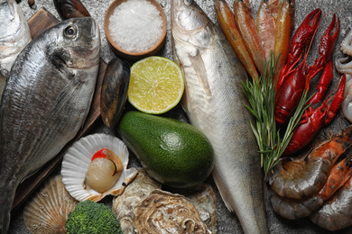 Photo of Fresh fish and different seafood on grey table, top view
