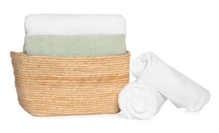 Photo of Wicker basket and soft terry towels on white background