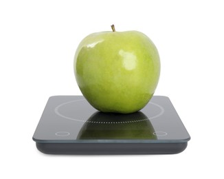 Photo of Ripe green apple and electronic scales on white background