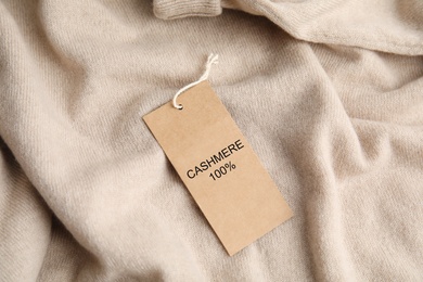 Image of Warm beige cashmere sweater with label, closeup
