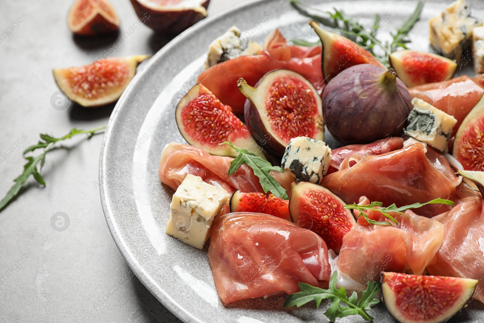 Photo of Plate with figs, prosciutto and cheese, closeup