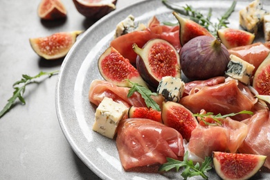 Photo of Plate with figs, prosciutto and cheese, closeup