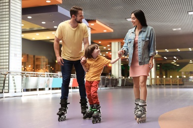 Happy family spending time at roller skating rink