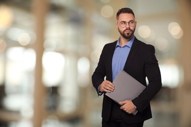 Successful lawyer with laptop on blurred background, space for text