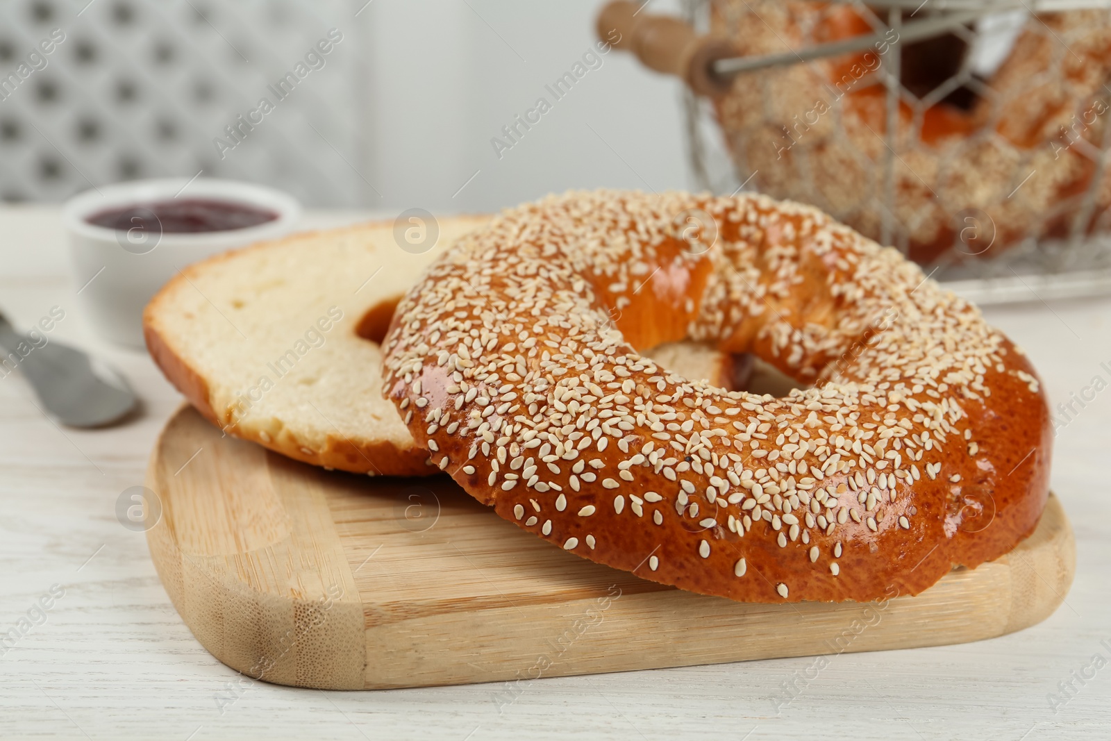Photo of Delicious fresh halved bagel on white wooden table, closeup