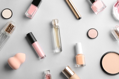 Photo of Flat lay composition with bottles of perfume and cosmetics on grey background