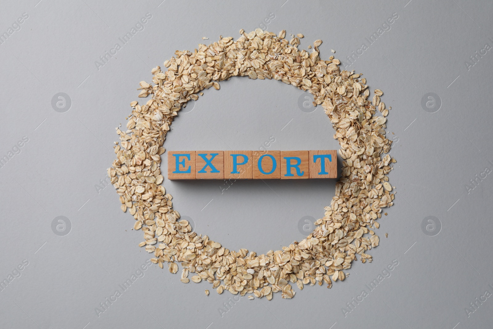 Photo of Frame of oatmeal and wooden cubes with word Export on grey table, flat lay