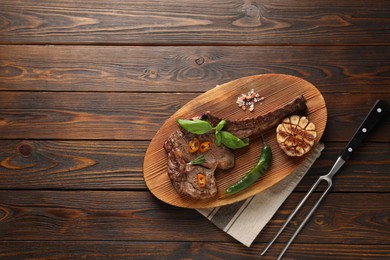 Photo of Delicious fried beef meat served on wooden table, flat lay. Space for text