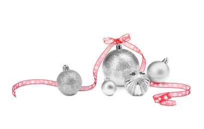 Photo of Beautiful Christmas balls and red ribbon isolated on white