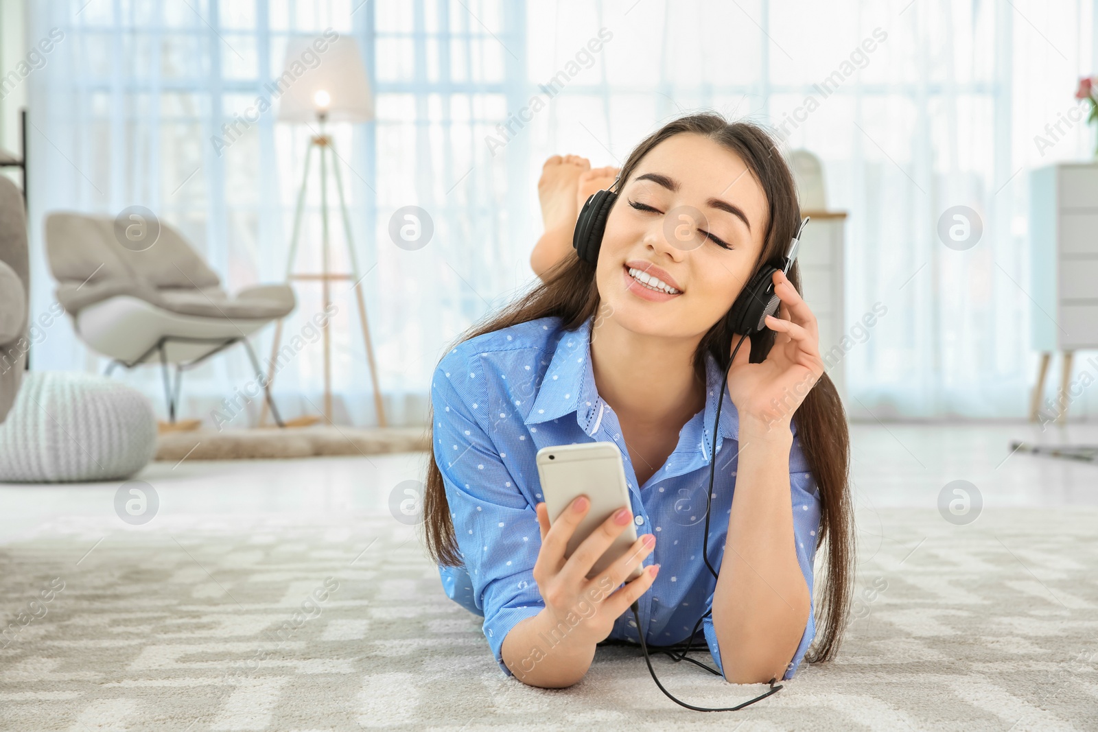 Photo of Beautiful young woman listening to music on mobile phone