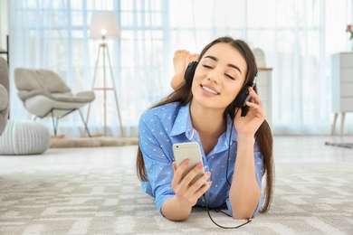 Photo of Beautiful young woman listening to music on mobile phone