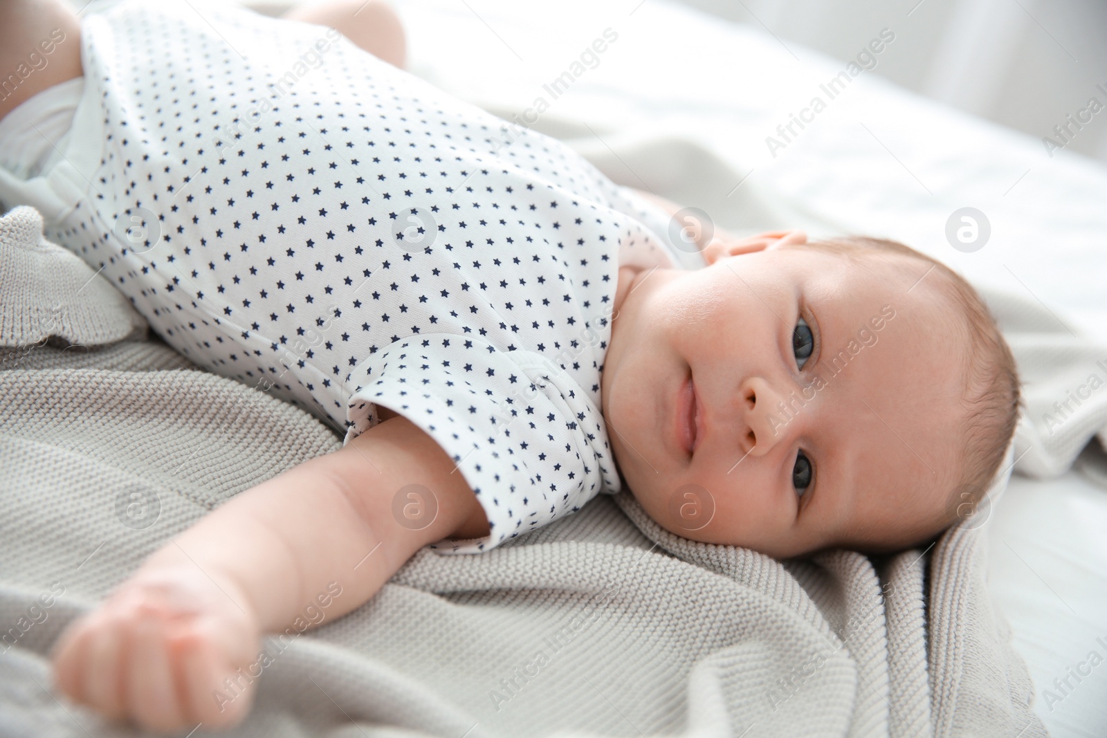 Photo of Adorable newborn baby lying on soft blanket