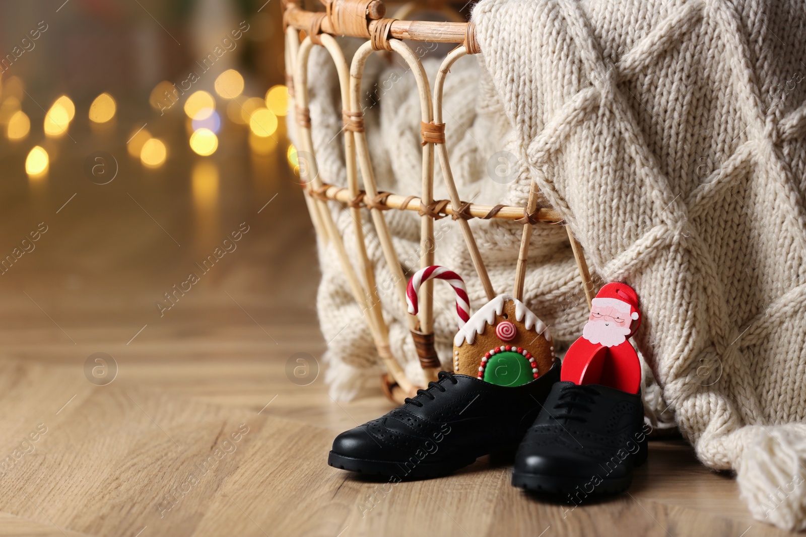 Photo of Shoes filled with sweets on floor in room, space for text. Saint Nicholas Day