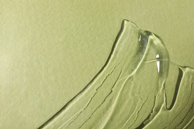 Photo of Transparent cosmetic gel on olive background, top view. Space for text