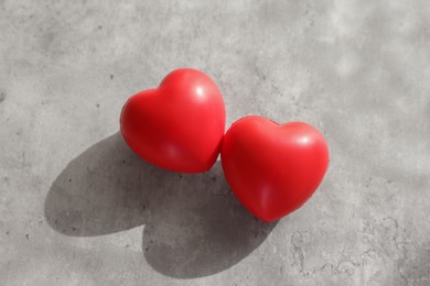 Photo of Two decorative hearts on gray textured table, above view