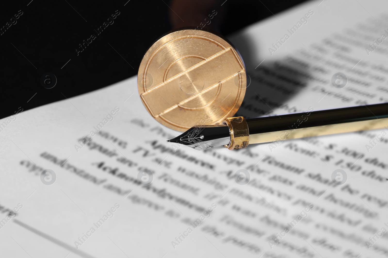 Photo of Fountain pen, wax stamp and paper document on table, closeup. Notary service