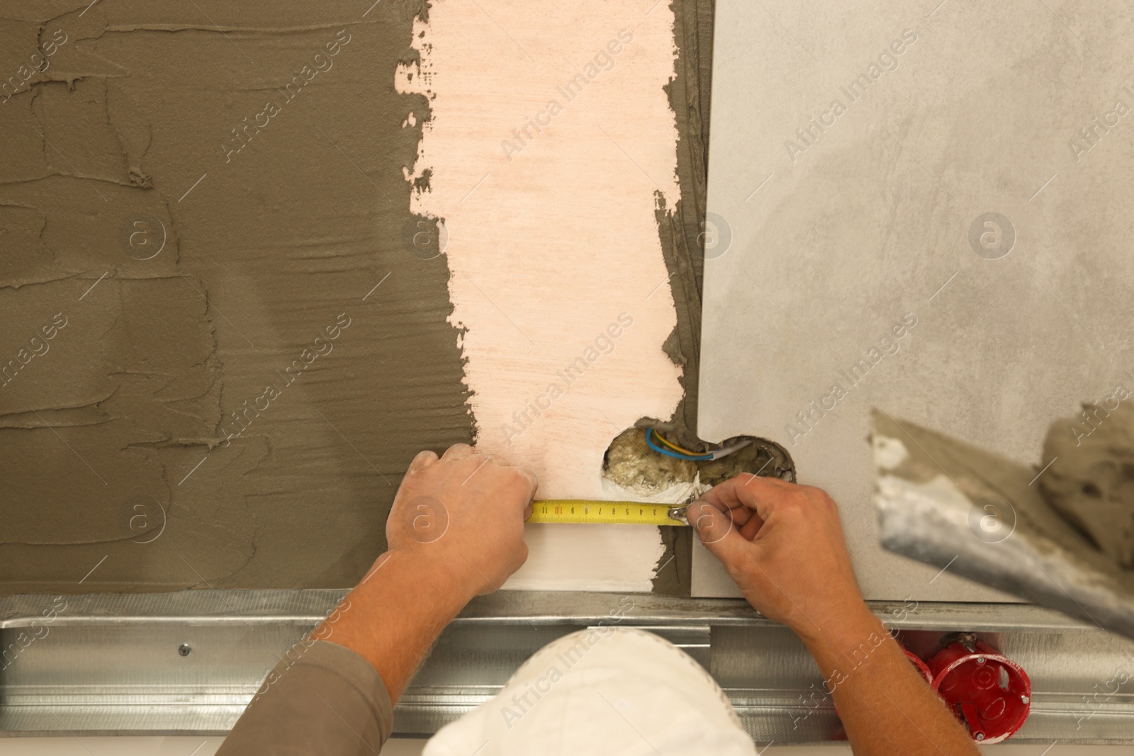 Photo of Worker installing tile in room, closeup. Home improvement