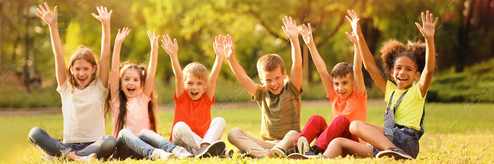 Image of Cute little children sitting on grass outdoors on sunny day. Banner design