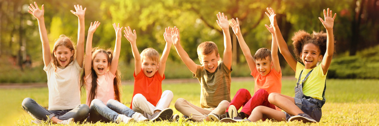 Image of Cute little children sitting on grass outdoors on sunny day. Banner design
