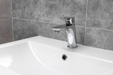Photo of Stylish white sink in public toilet interior