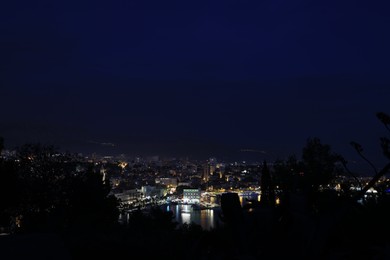 SPLIT, CROATIA - OCTOBER 08, 2023: Beautiful view of illuminated city with port and buildings at night
