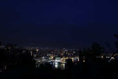 Photo of SPLIT, CROATIA - OCTOBER 08, 2023: Beautiful view of illuminated city with port and buildings at night