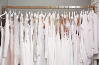 Photo of Different wedding dresses on hangers in boutique