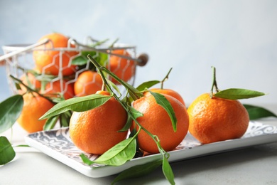 Photo of Plate with tasty ripe tangerines on table