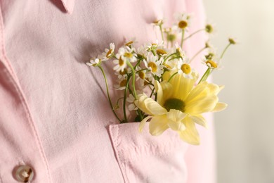 Photo of Woman with beautiful tender flowers in shirt's pocket, closeup