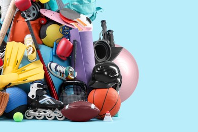 Photo of Many different sports equipment on light blue background