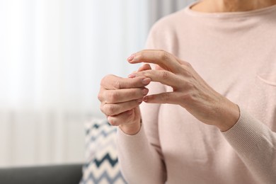 Photo of Arthritis symptoms. Woman suffering from pain in finger at home, closeup. Space for text