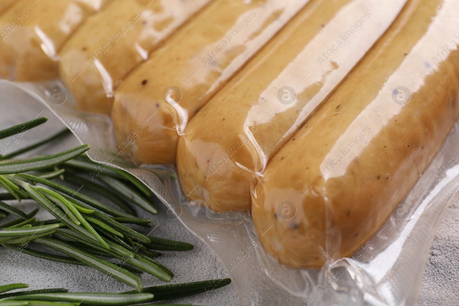 Photo of Vegan sausages and rosemary on white table, closeup