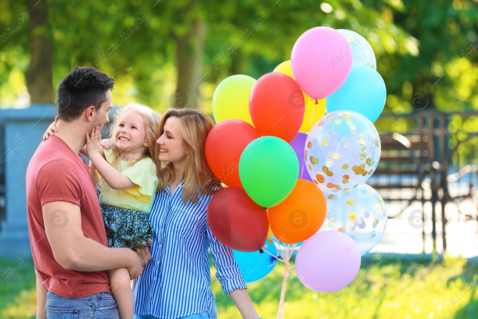 Photo of Happy family with colorful balloons in park on sunny day