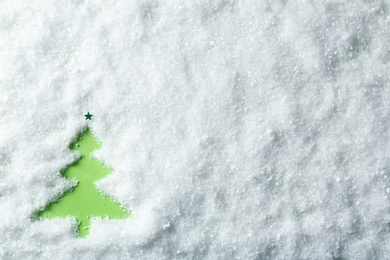 Photo of Christmas tree silhouette in snow on color background, top view with space for text