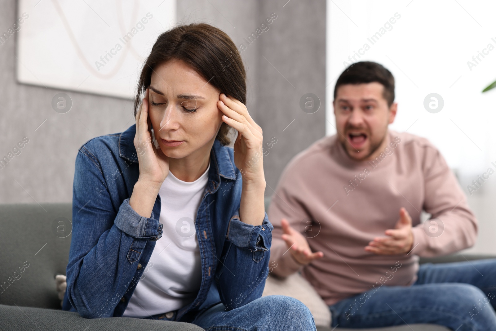 Photo of Offended wife ignoring her angry husband indoors, selective focus. Relationship problems