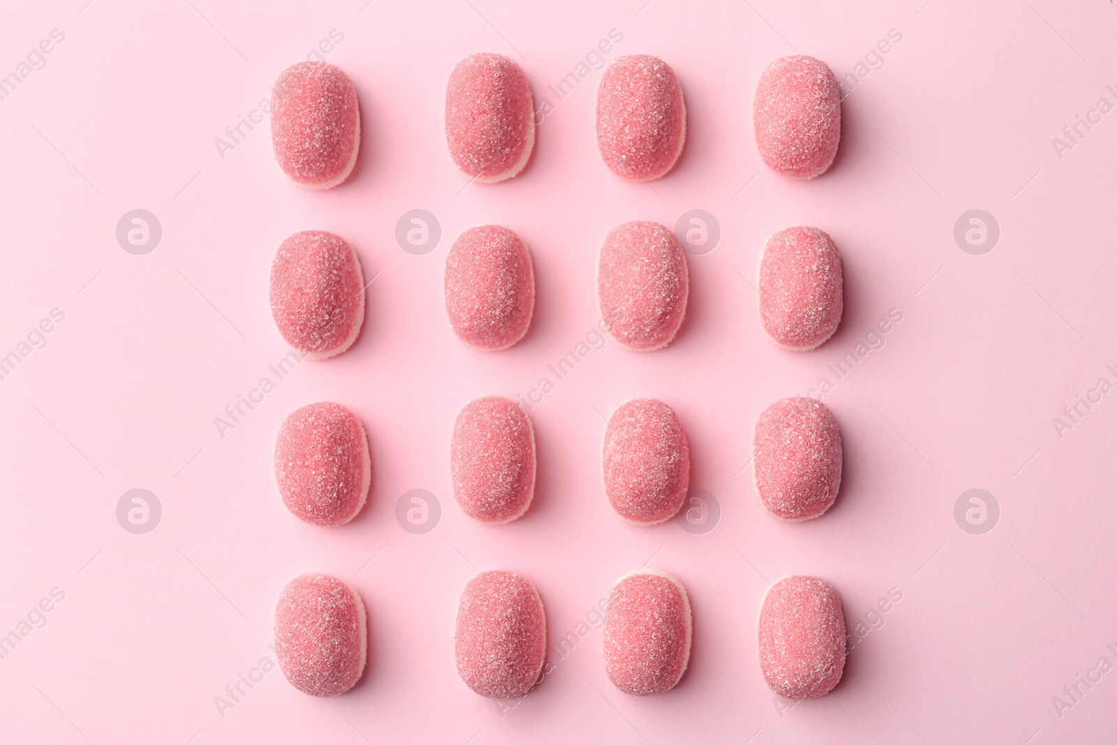 Photo of Sweet jelly candies on pink background, flat lay