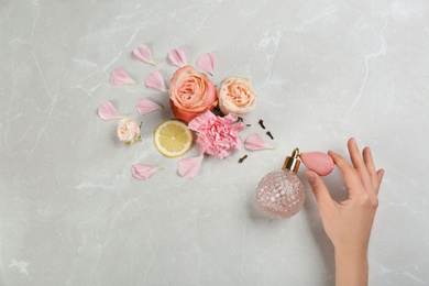 Photo of Woman with perfume. Fragrance composition, flowers and lemon on marble background,  top view