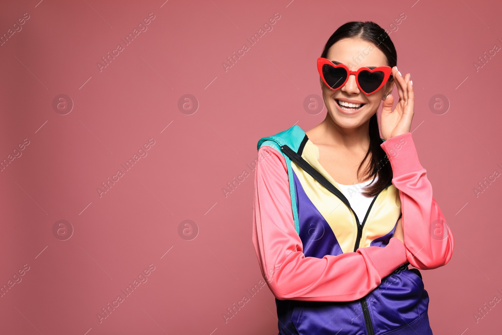 Photo of Portrait of beautiful young woman with heart shaped sunglasses on color background. Space for text
