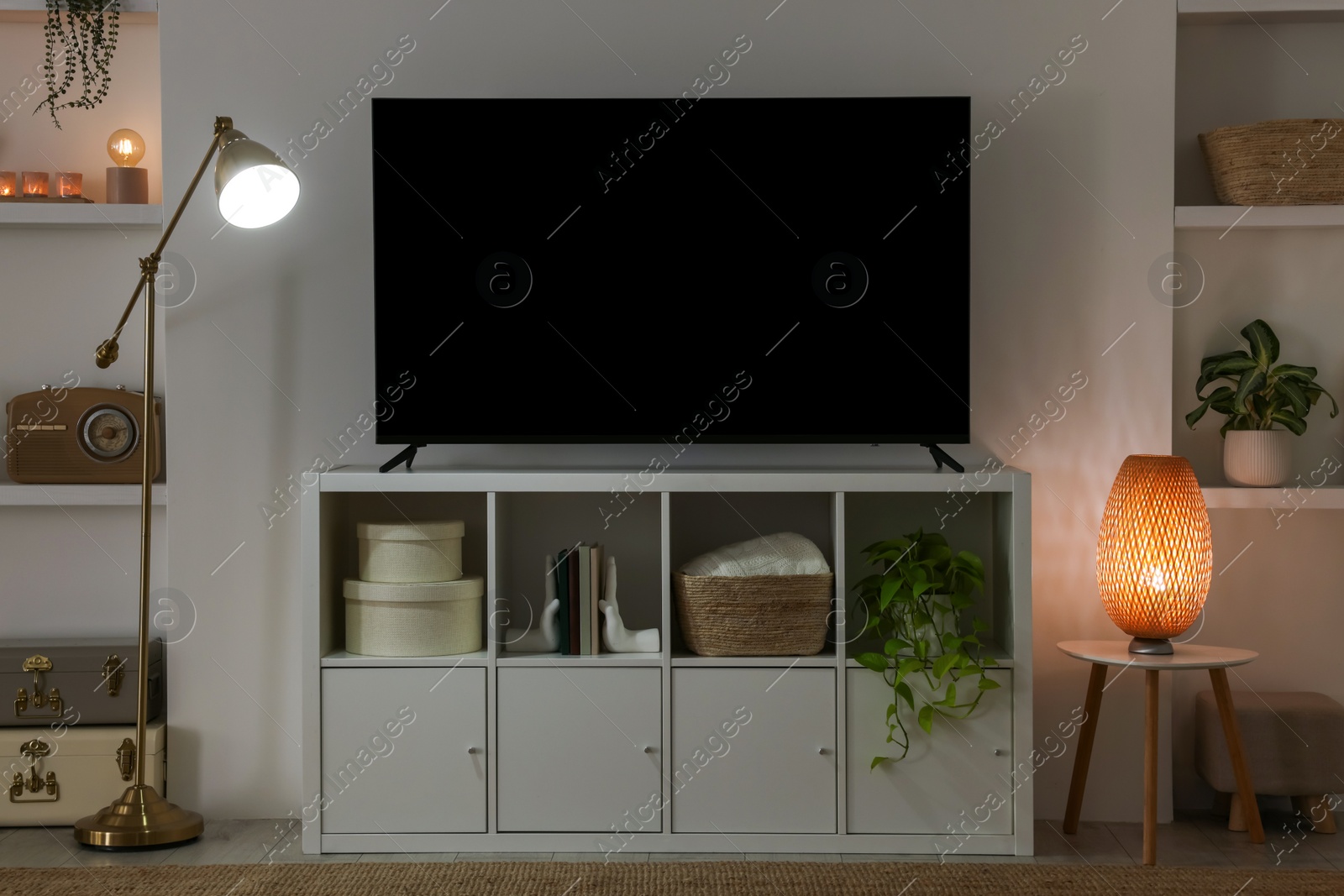 Photo of Stylish wide TV set on stand in room