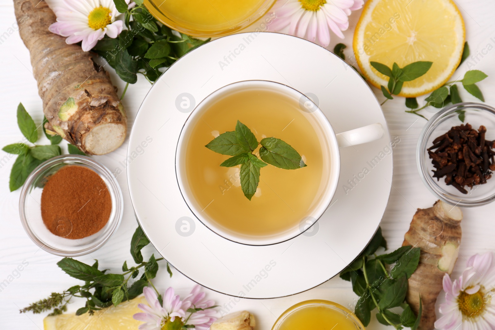 Photo of Flat lay composition with cup of delicious tea, honey and ginger on white wooden table