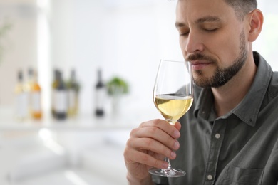 Photo of Man with glass of delicious wine indoors
