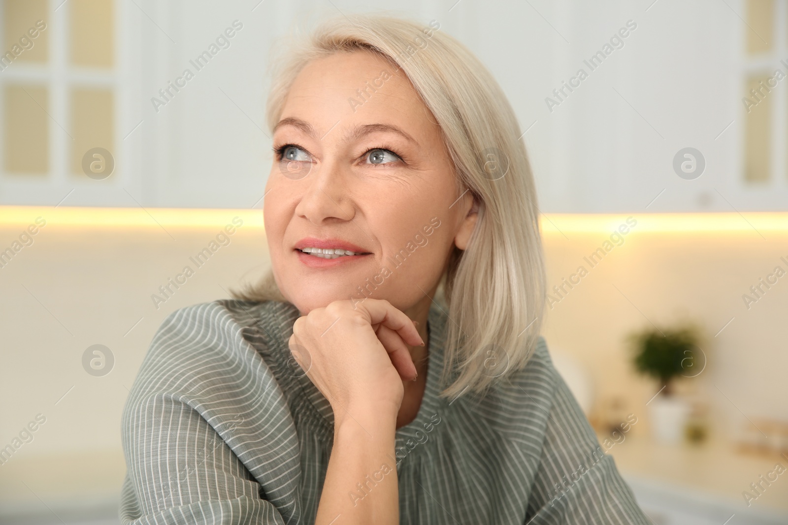 Photo of Portrait of beautiful mature woman in kitchen