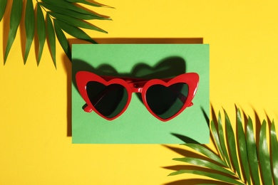 Photo of Flat lay composition with stylish heart shaped glasses on color background