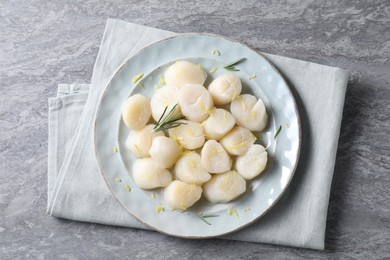 Raw scallops with lemon zest and rosemary on grey marble table, top view