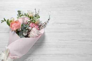 Bouquet of beautiful flowers on white wooden table, top view. Space for text