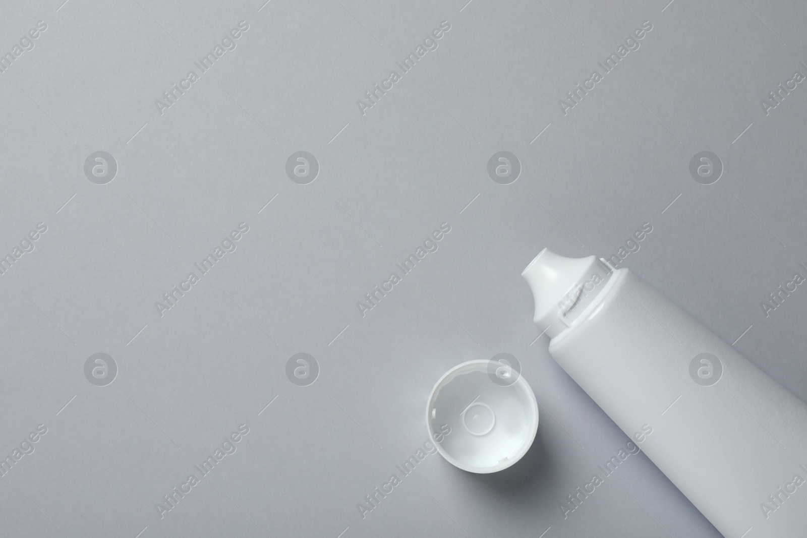 Photo of Blank tube of toothpaste on light grey background, top view. Space for text