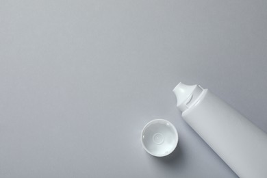 Photo of Blank tube of toothpaste on light grey background, top view. Space for text