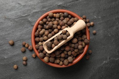 Photo of Dry allspice berries (Jamaica pepper) on black table, top view